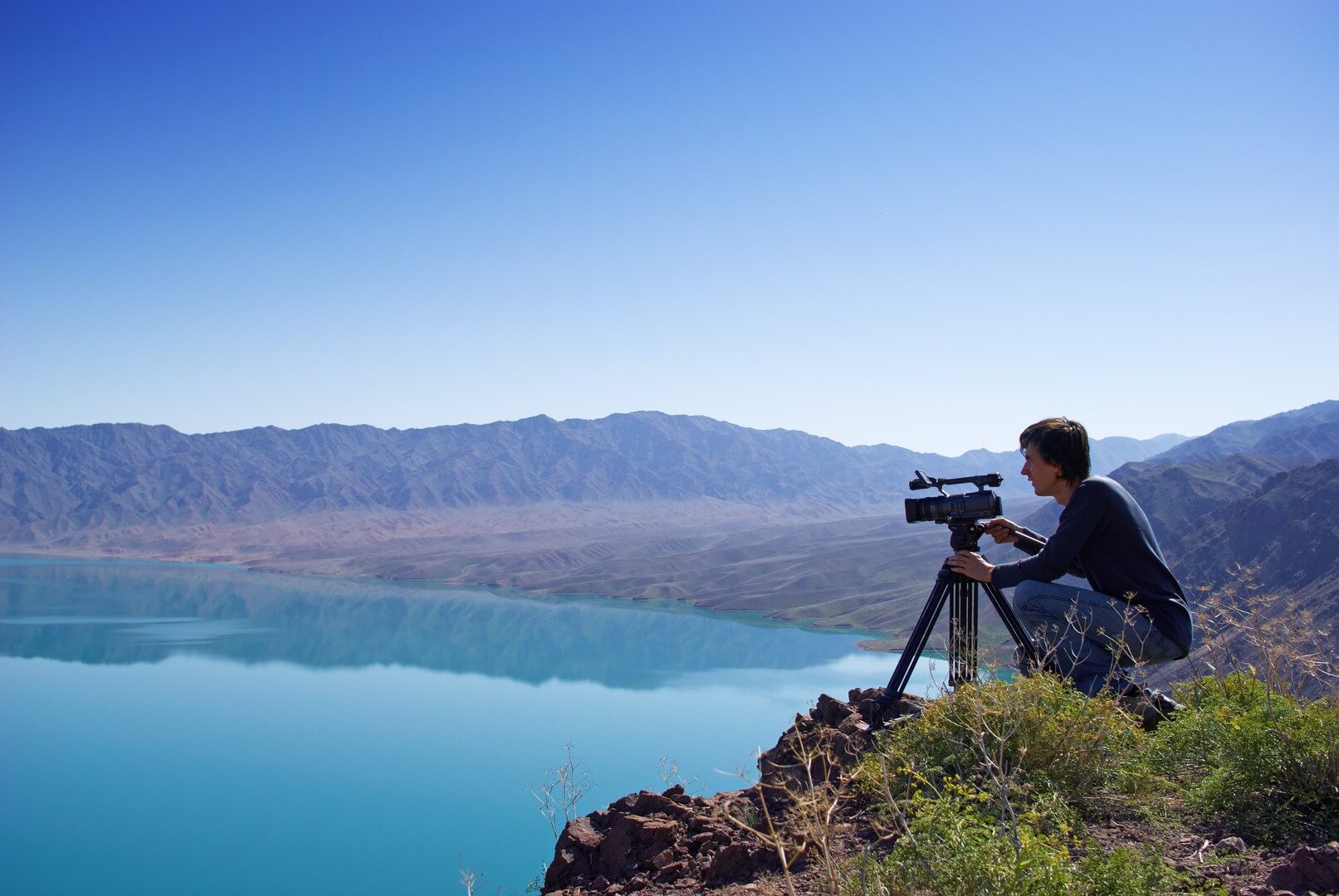 The man whith photo camera near the water